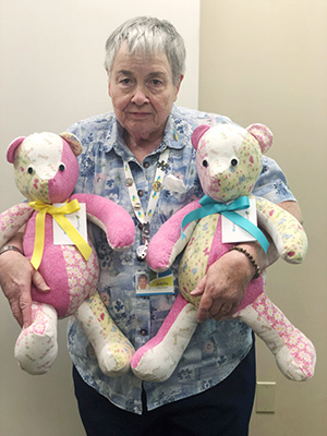 Volunteer holding handmade bears